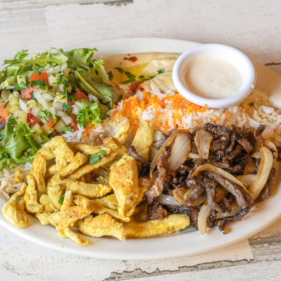 Baba Pita's Mediterranean plate with chicken, beef, rice, salad, hummus, and sauce.